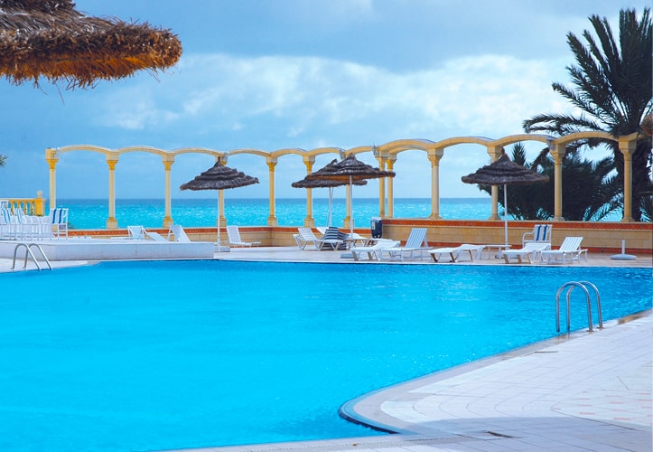 Piscine extérieure avec vue sur mer  et chaises longues à l'hotel Les Colombes
